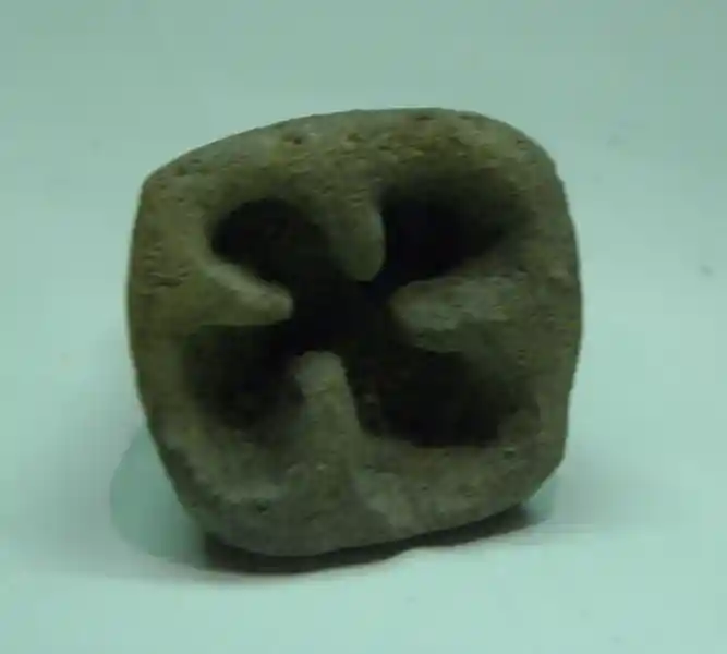 A cross resembling a rounded swastika engraved on a stone